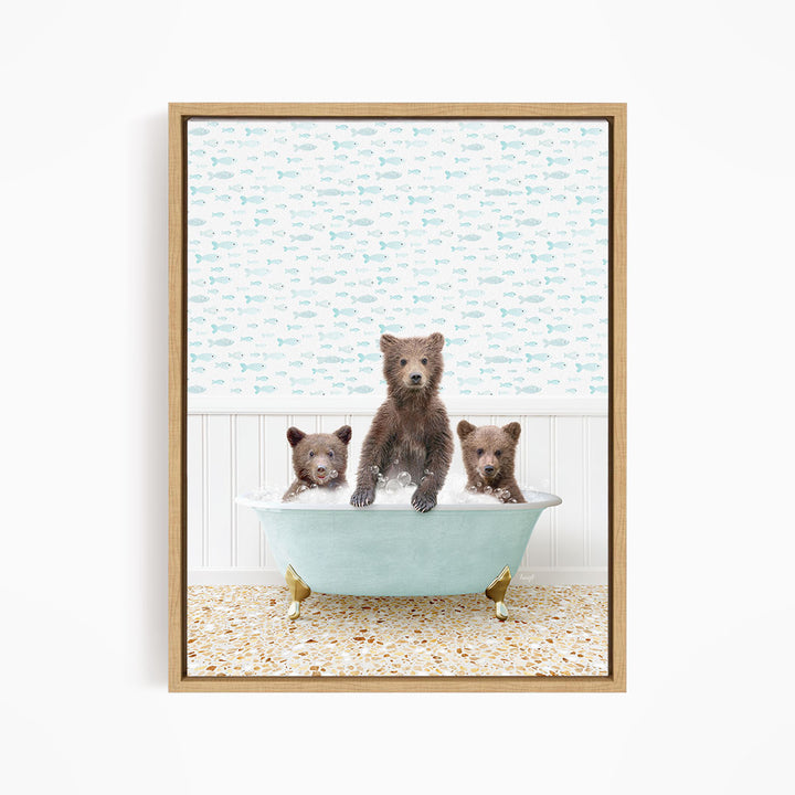 A framed image depicting three bears sitting in a bathtub filled with water, with a patterned wall behind them.
