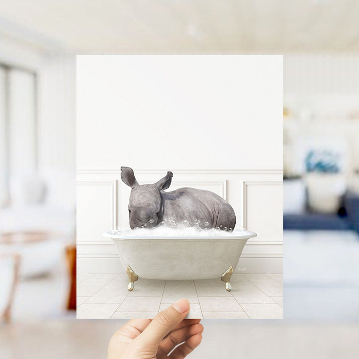 A rhinoceros is sitting in a bathtub filled with bubbles, creating a whimsical and playful scene.