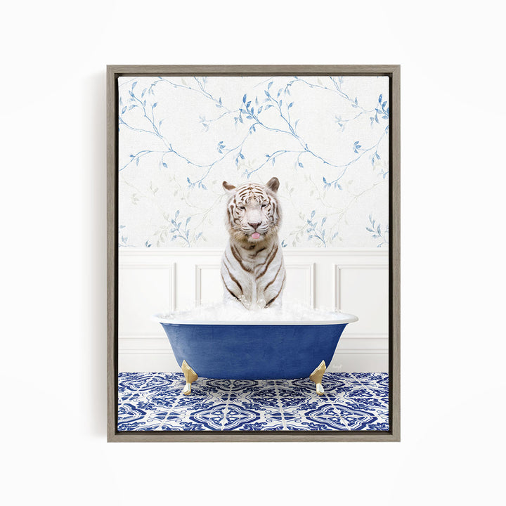 A white tiger is sitting in a blue bathtub filled with water, surrounded by a blue and white patterned rug on the floor.
