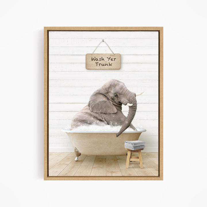 A gray elephant sitting in a bathtub, with a wooden sign above it that says "Wash Yer Trunk".