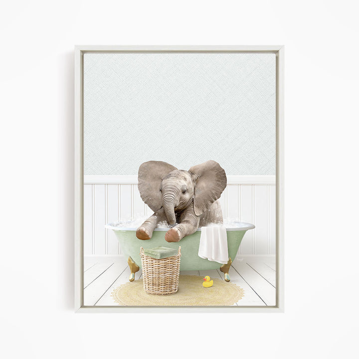 A baby elephant sitting in a green bathtub, surrounded by a basket of toys and a yellow rubber duck.