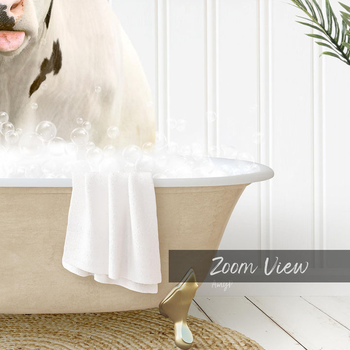 A cow is sitting in a bathtub filled with bubbles, with a towel and a gold object nearby.