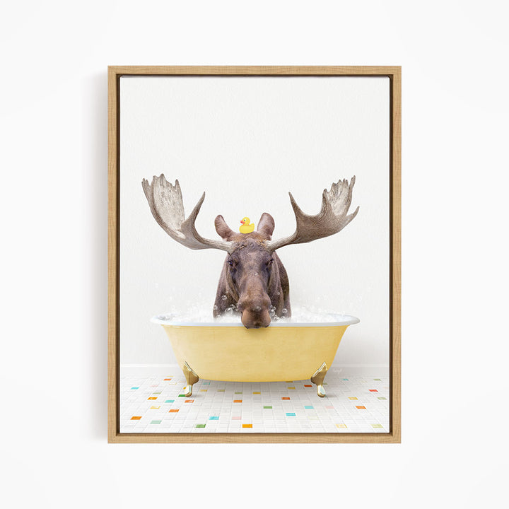 A moose with large antlers is sitting in a yellow bathtub, with a rubber duck floating on its head.