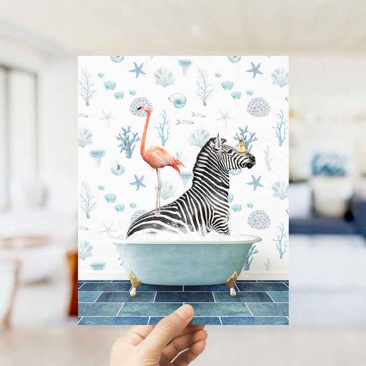 A hand is holding up a print featuring a zebra sitting in a bathtub, with a flamingo standing on its back.