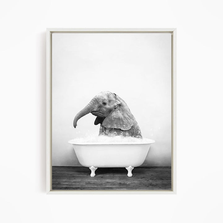 A baby elephant sitting in a bathtub filled with water, appearing to enjoy the bath.