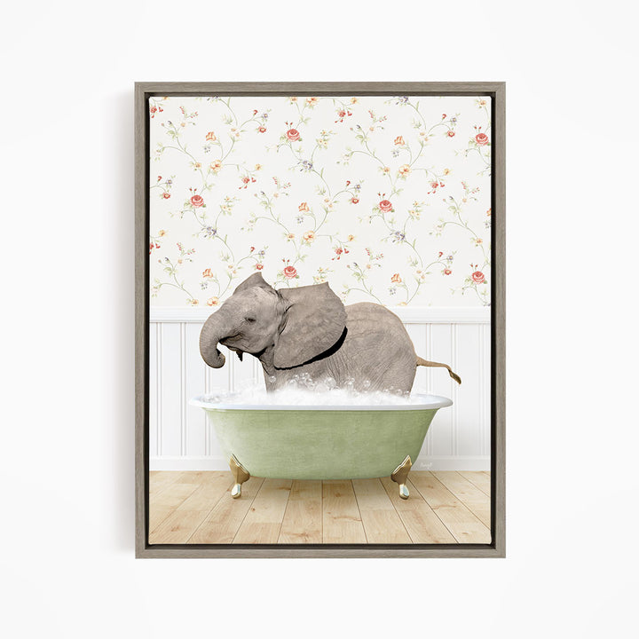 A gray elephant is sitting in a green bathtub filled with water, surrounded by a floral wallpaper.