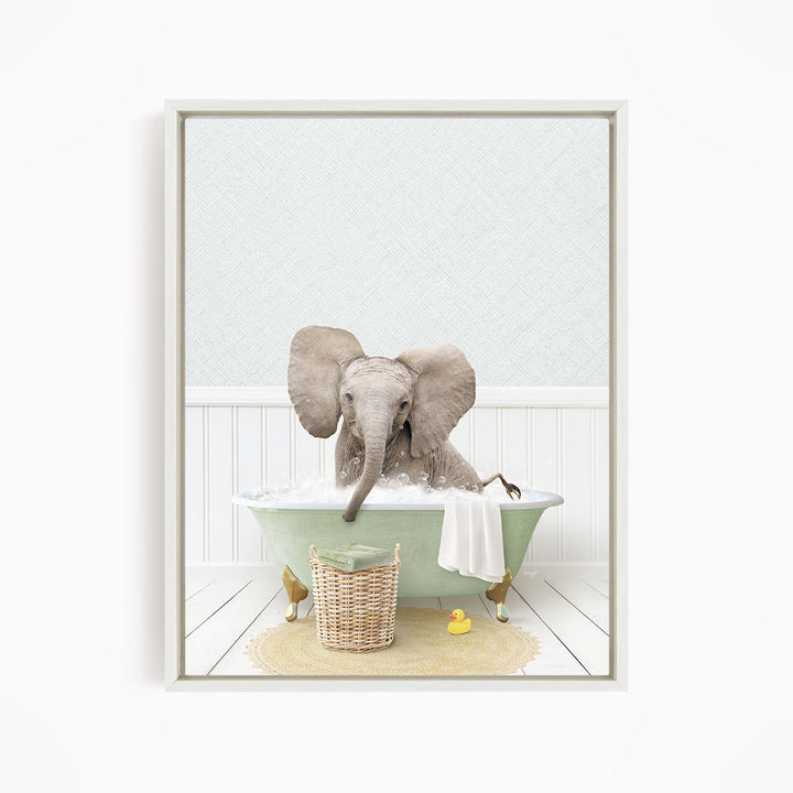 A gray elephant is sitting in a green bathtub filled with water, surrounded by a yellow rubber duck and a basket.