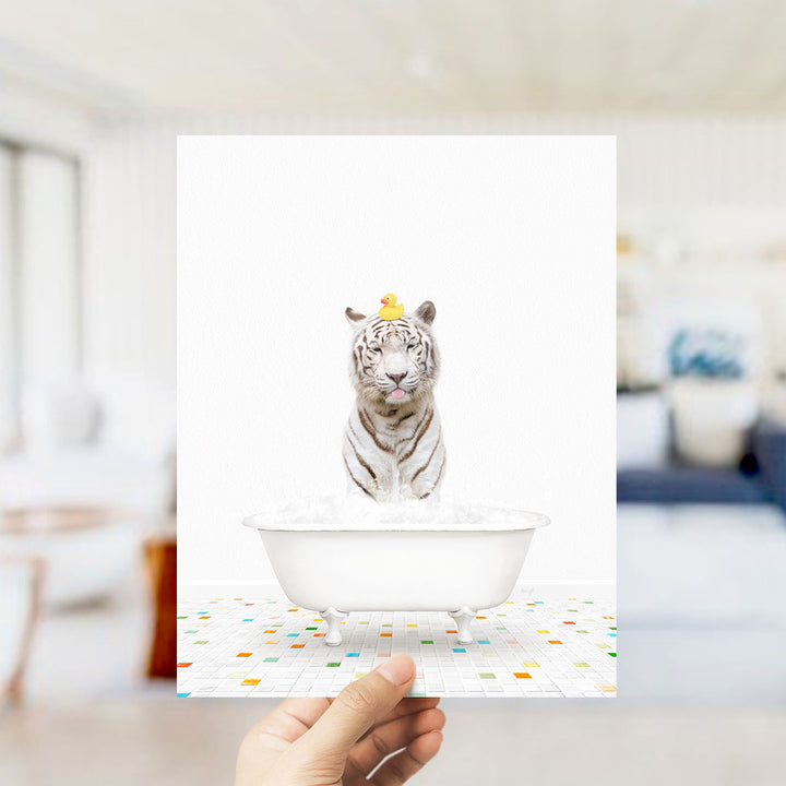 A white tiger is sitting in a white bathtub filled with bubbles, with a yellow rubber duck perched on its head.