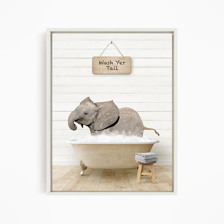A framed image depicting a baby elephant sitting in a bathtub, with a sign above that says "Wash yer tail".