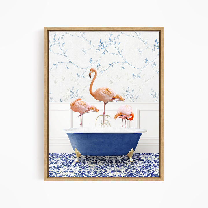 A framed image depicting three flamingos standing in a blue bathtub, with a patterned tile floor and a floral wallpaper in the background.