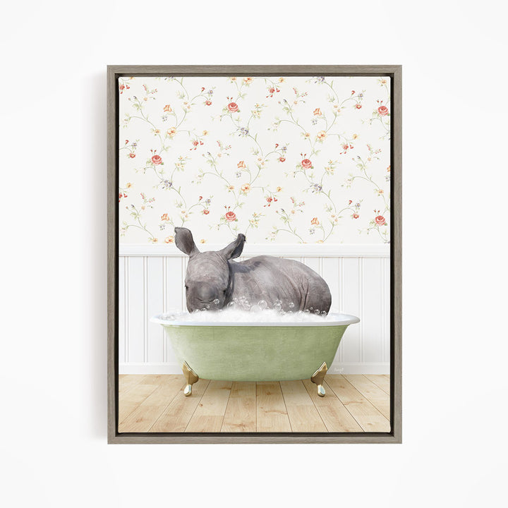 A rhinoceros is sitting in a green bathtub filled with water, surrounded by a floral wallpaper.