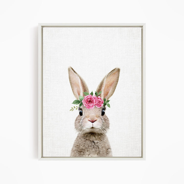 A cute rabbit wearing a pink flower crown on its head, looking directly at the camera.