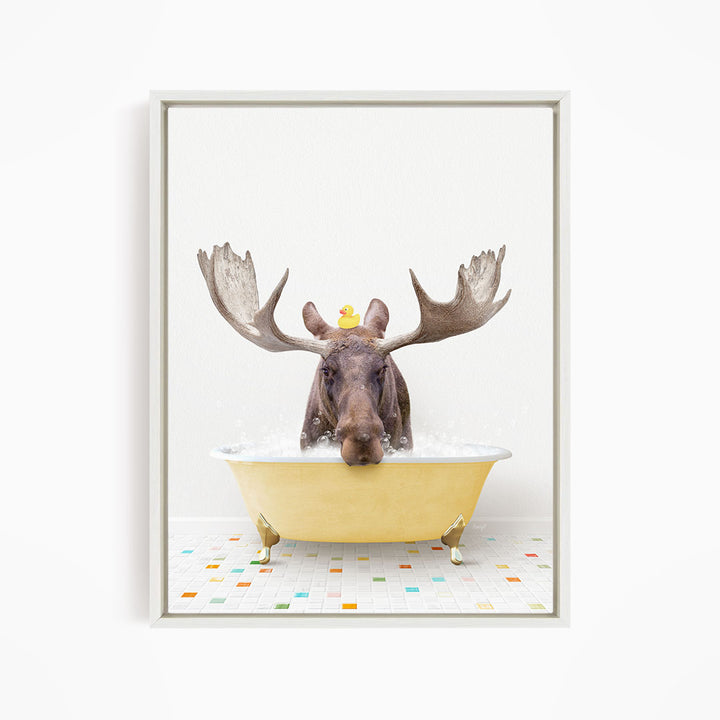A moose with large antlers is sitting in a yellow bathtub, with a rubber duck floating on its head.