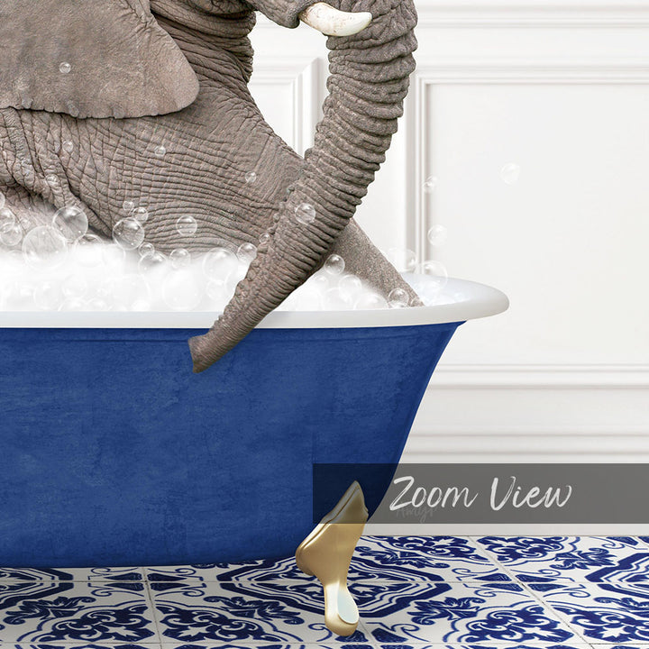 A large gray elephant is sitting in a blue bathtub filled with bubbles, with its trunk submerged in the water.