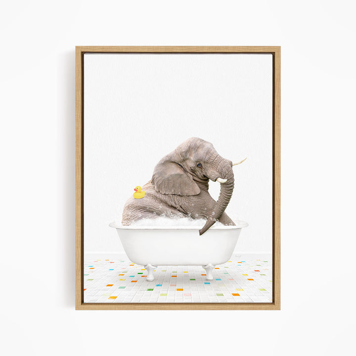 A gray elephant is sitting in a white bathtub, with a yellow rubber duck floating on the water.