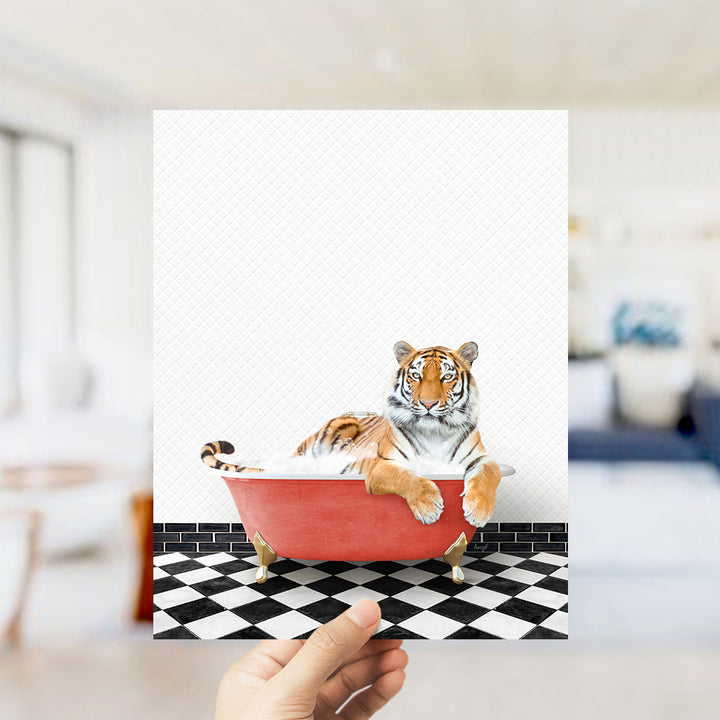 A tiger is sitting in a red bathtub on a black and white checkered floor.