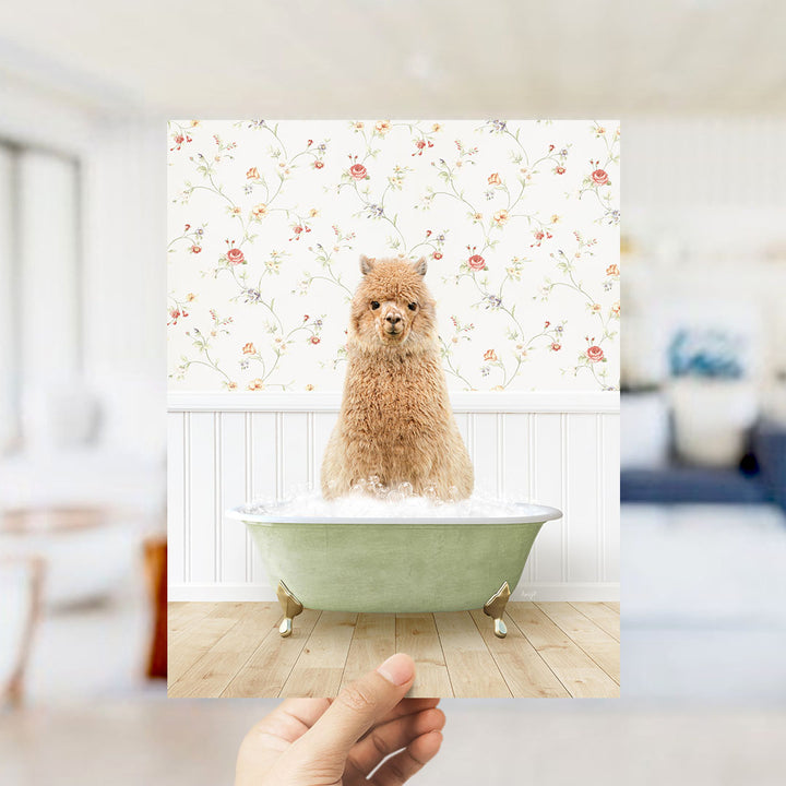 A fluffy brown alpaca sitting in a green bathtub filled with bubbles, surrounded by a floral wallpaper.
