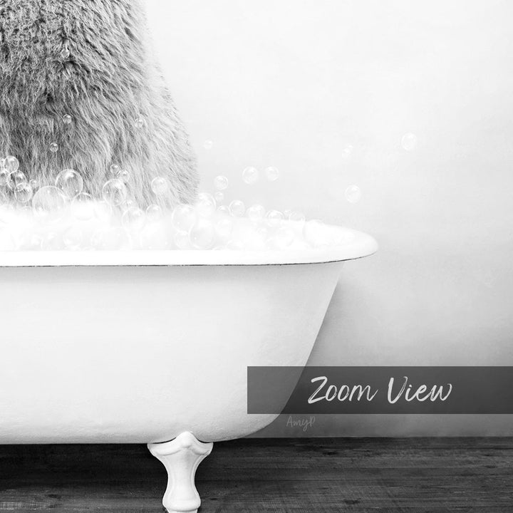 A white claw-foot bathtub filled with bubbles, with a furry object partially visible on the left side.