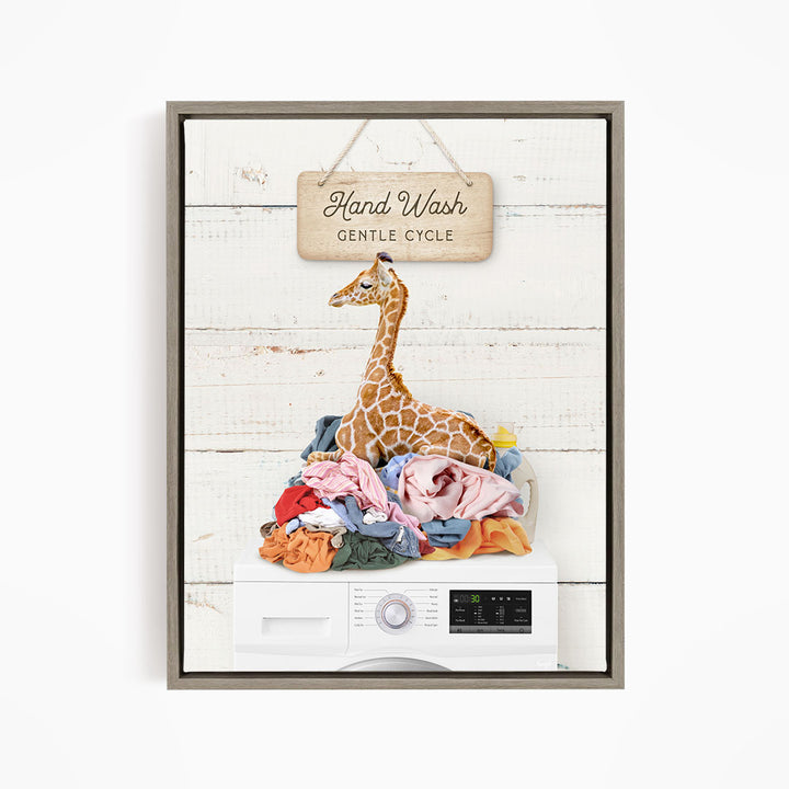 A giraffe sitting on a pile of laundry with a sign above it that says "Hand Wash Gentle Cycle".