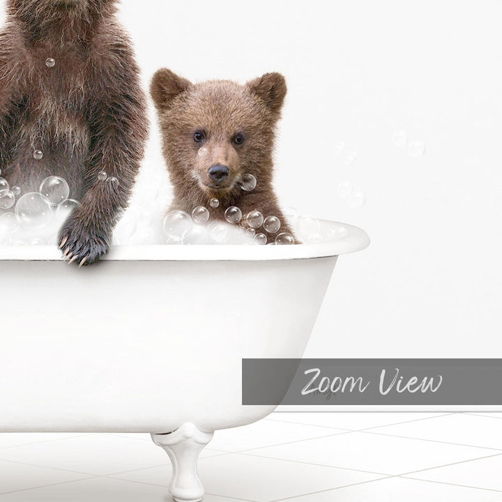 A baby bear sitting in a bathtub filled with bubbles, with a white bathtub and a white tiled floor in the background.
