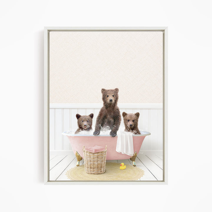 A framed image depicting three brown bears sitting in a pink bathtub, with a yellow rubber duck nearby.