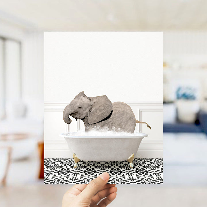 A gray elephant is sitting in a white bathtub filled with bubbles, surrounded by a black and white patterned floor.