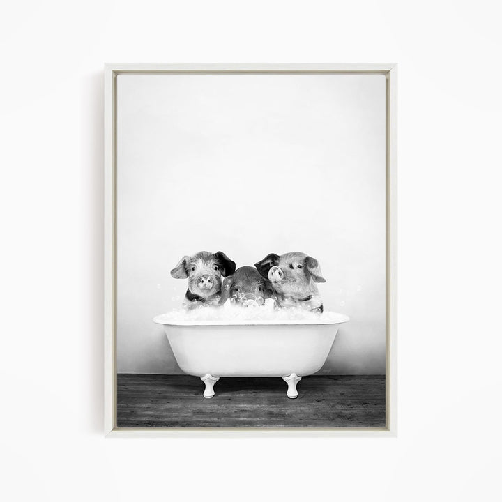 A black and white image of three dogs sitting in a bathtub, with one dog in the center and the other two on either side.