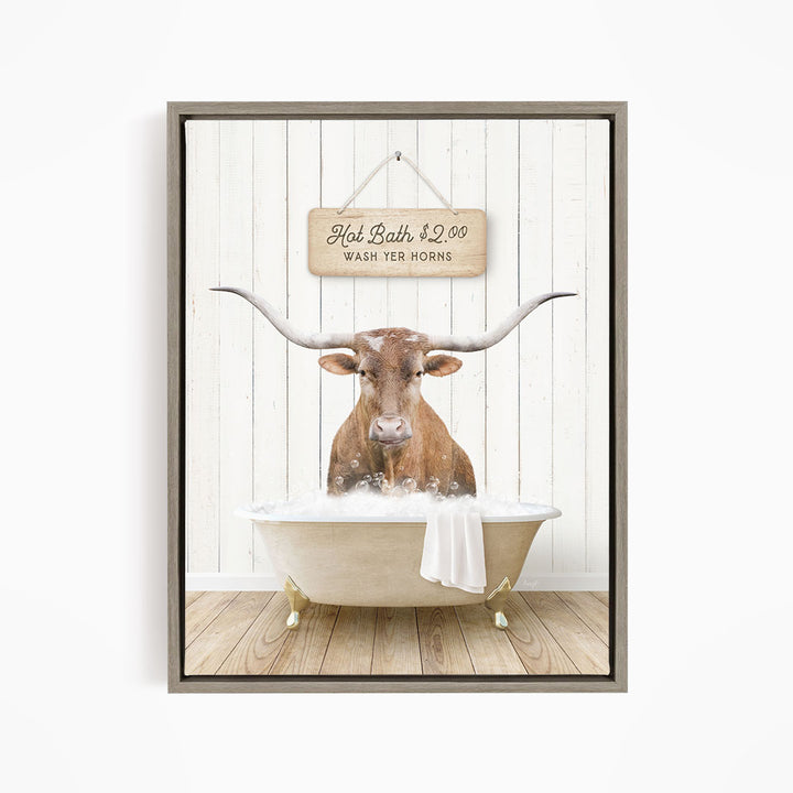 A brown cow with large horns is sitting in a white bathtub, with a wooden sign above it that reads "Hot Bath $2.00 WASH YER HORSES".