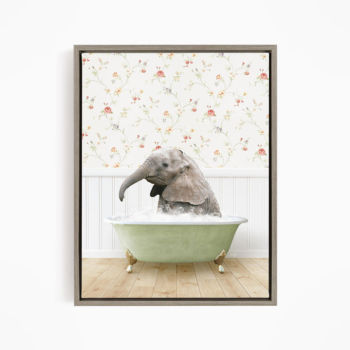 A baby elephant sitting in a green bathtub filled with water, surrounded by a floral wallpaper.