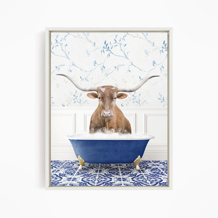 A brown cow with large horns is sitting in a blue bathtub filled with bubbles, surrounded by a blue and white patterned floor.