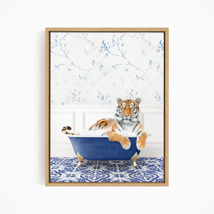 A tiger is sitting in a blue bathtub, surrounded by a patterned tile floor and a floral wallpaper background.