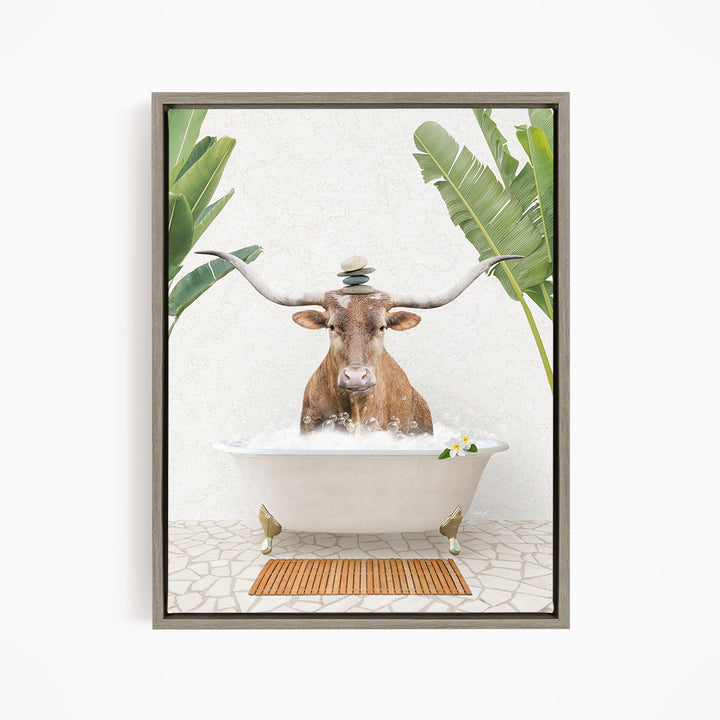 A bull with large horns is sitting in a white bathtub filled with water, surrounded by tropical plants and a wooden mat on the floor.