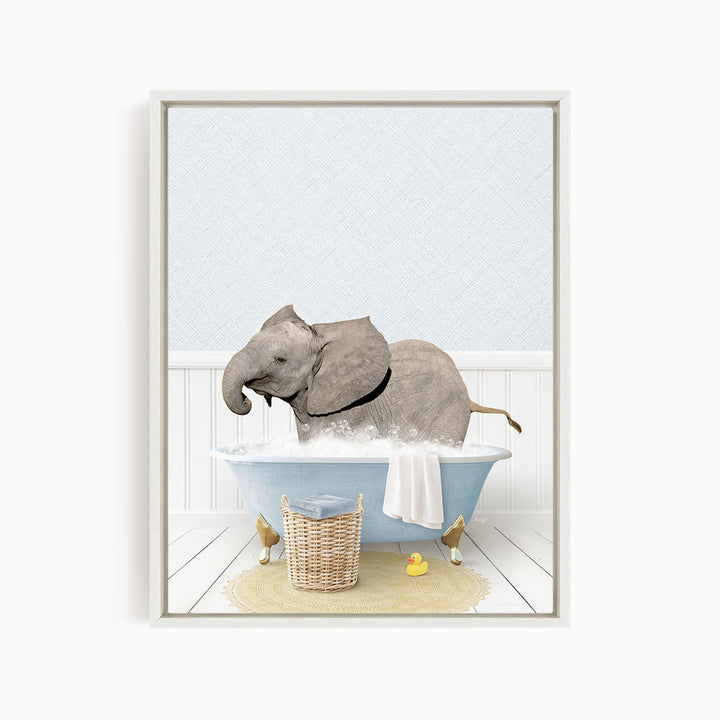 A gray elephant is sitting in a blue bathtub filled with water, surrounded by a yellow rubber duck and a basket.