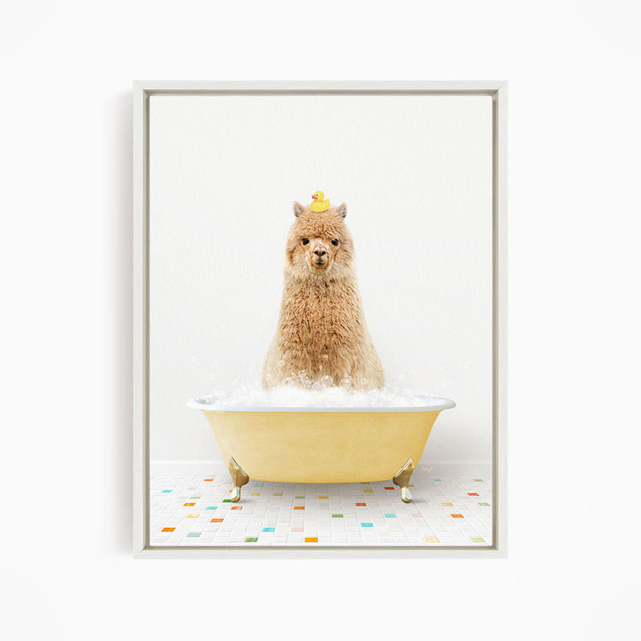 A fluffy brown alpaca sits in a yellow bathtub filled with bubbles, with a yellow rubber duck perched on its head.