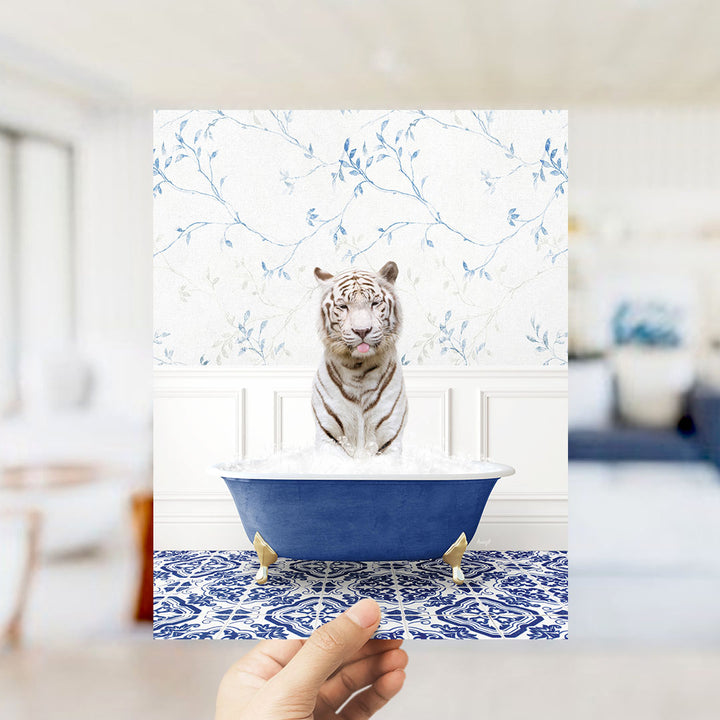 A white tiger sitting in a blue bathtub filled with water, with a patterned tile floor in the background.