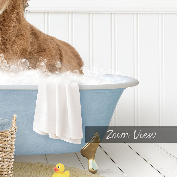 A dog is sitting in a blue bathtub filled with bubbles, surrounded by a yellow rubber duck and a white towel.