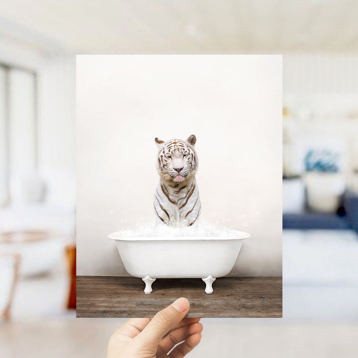 A white tiger sitting in a white bathtub filled with water, with a blurred background suggesting a bathroom setting.