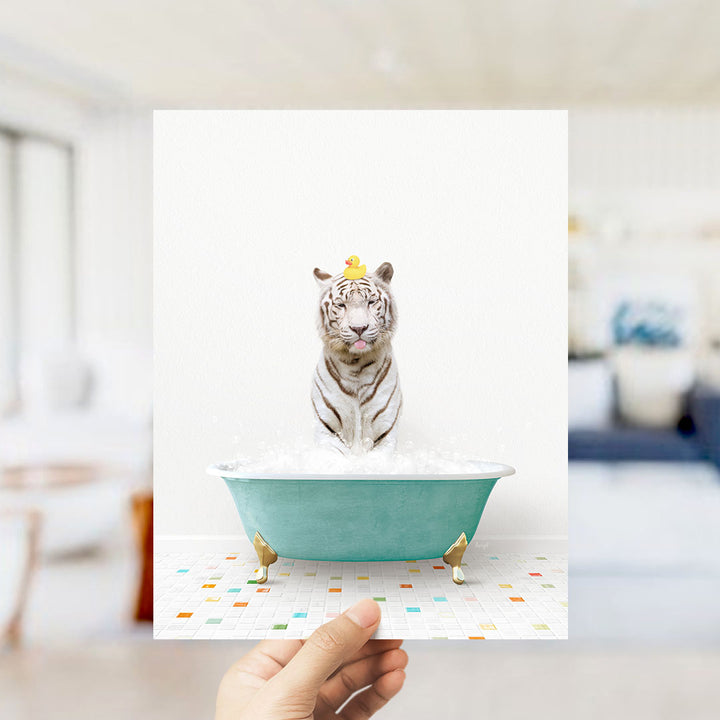 A white tiger is sitting in a green bathtub filled with bubbles, with a yellow rubber duck perched on its head.