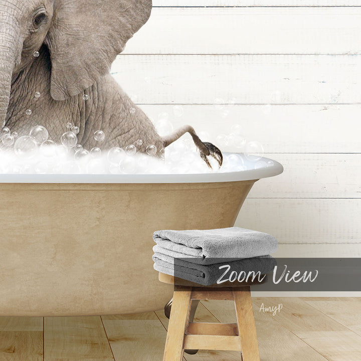A large elephant is taking a bath in a bathtub, surrounded by bubbles, with a towel and stool visible in the foreground.