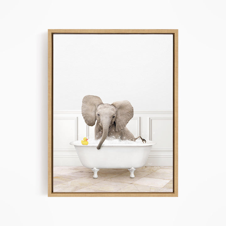 A baby elephant sitting in a white bathtub, with a yellow rubber duck floating on the water.