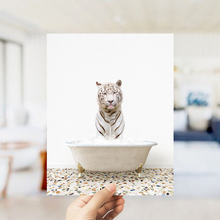 A white tiger is sitting in a bathtub filled with water, with its mouth open and tongue sticking out.