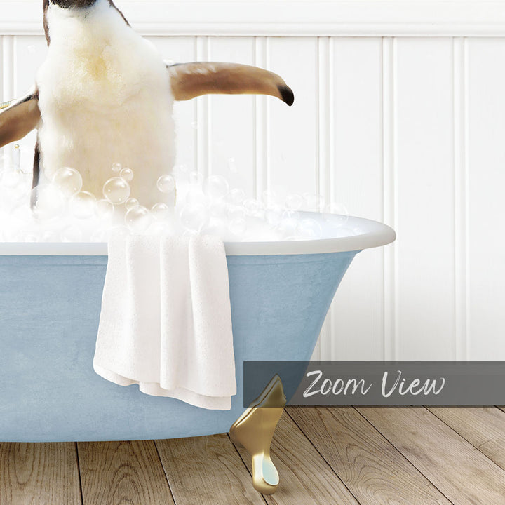 A penguin sitting in a blue bathtub filled with bubbles, with a towel draped over the side and a "Zoom View" label below the image.