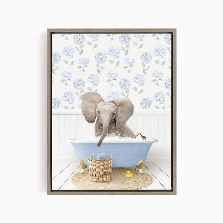 A gray elephant is sitting in a blue bathtub filled with water, surrounded by a wicker basket and yellow rubber ducks.