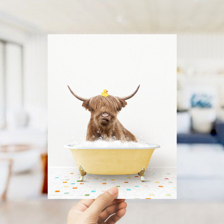 A brown cow with horns is sitting in a yellow bathtub filled with bubbles, with a yellow rubber duck perched on its head.