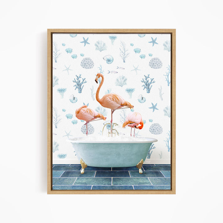 A framed print depicting three flamingos standing in a bathtub filled with bubbles, surrounded by a blue and white floral pattern.