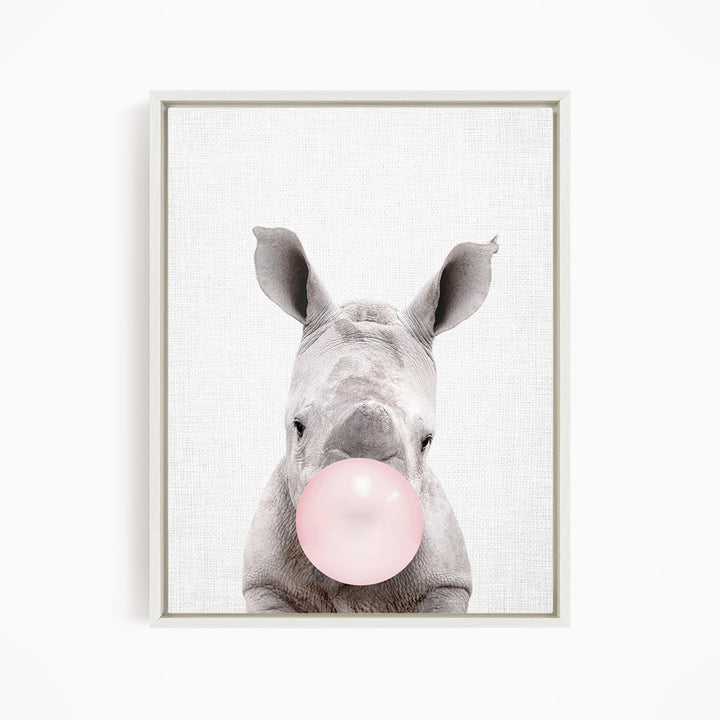 A rhinoceros blowing a pink bubble with its mouth.