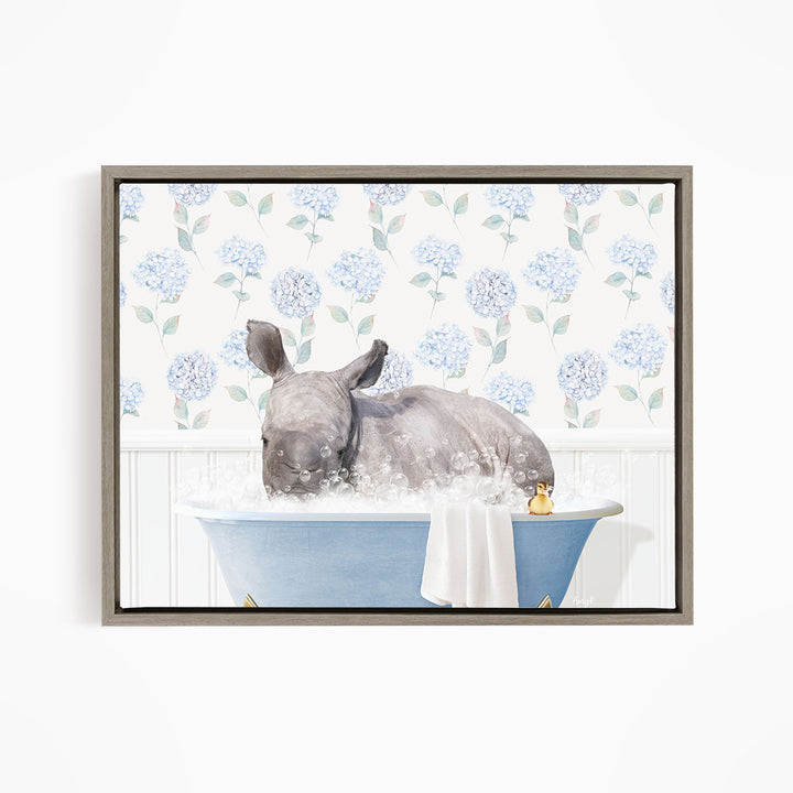 A rhinoceros is sitting in a blue bathtub filled with water, surrounded by a floral patterned wall.