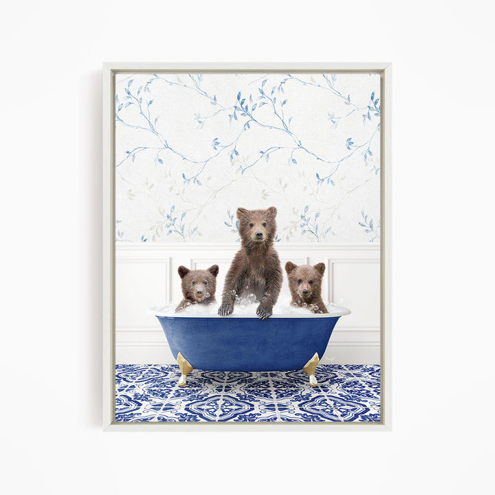 A framed image depicting three bears sitting in a blue bathtub, with a patterned tile floor and a floral wallpaper in the background.
