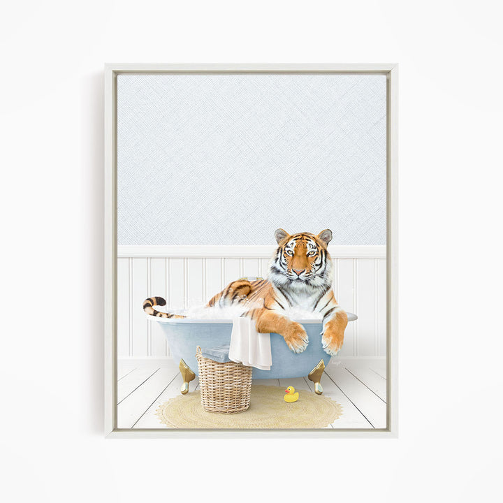 A tiger is sitting in a bathtub filled with water, surrounded by a basket of toys and a yellow rubber duck.