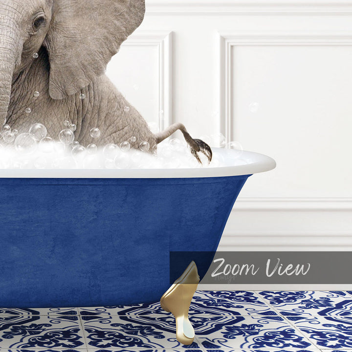 A large elephant is sitting in a blue bathtub filled with bubbles, with its trunk raised in the air.